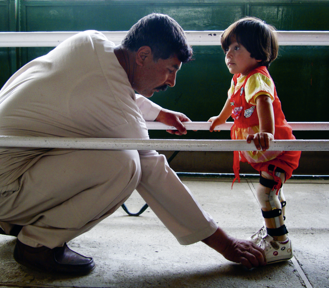 Kaboul, centre orthop dique  Un p re corrige la posture de sa fille pendant qu'elle apprend   marcher avec un appareil orthop dique  Kabul, Orthopaedic Centre  A father corrects the posture of his daughter as she learns to walk with her orthopaedic support 
